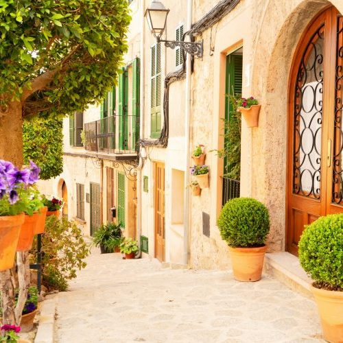 Altstadt Sineu auf Mallorca eine Straße mit Blumen und Steingebäuden