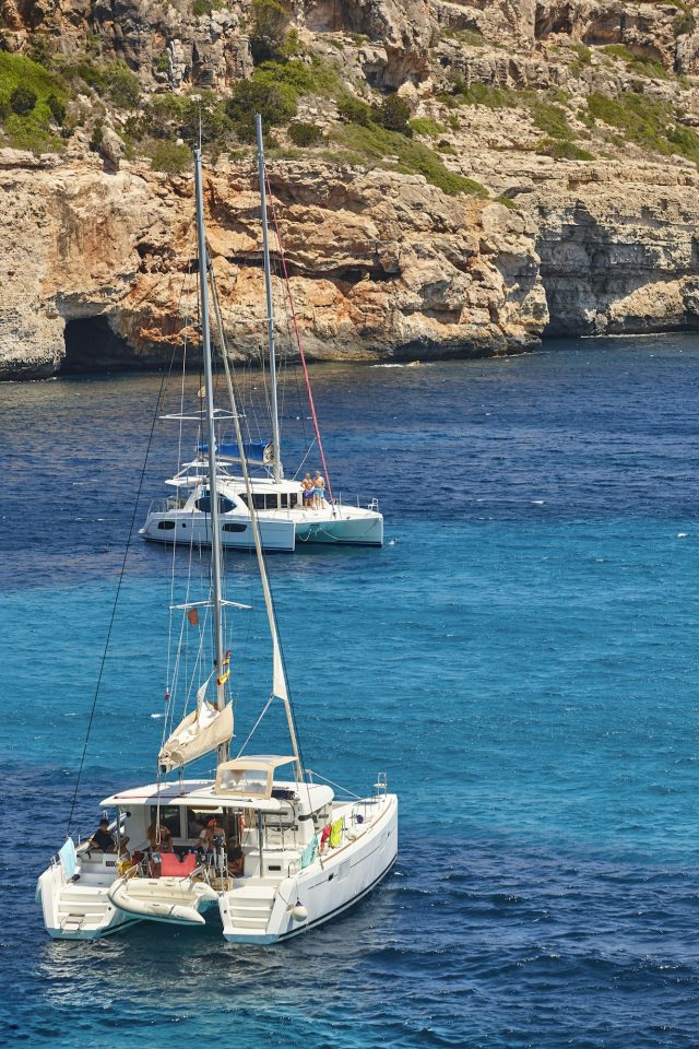 Cala Ratjada bay with turquoise waters and catamaran
