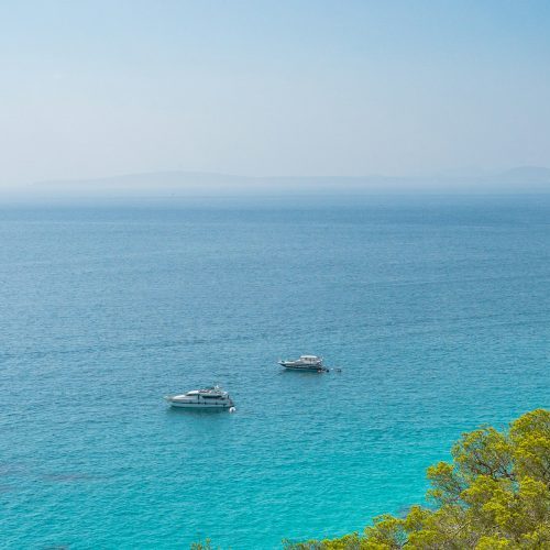 Boats near the coast with crystal clear water in Les Palmeres on the island of Mallorca