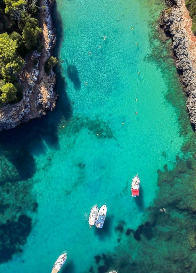 Boats in the turquoise waters of Cala Llombards Mallorca