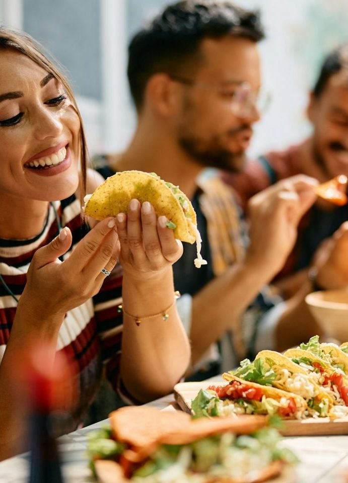 Frau isst Mittagessen mit Freunden auf einem Dorffest in Lloret de Vistalegre auf Mallorca