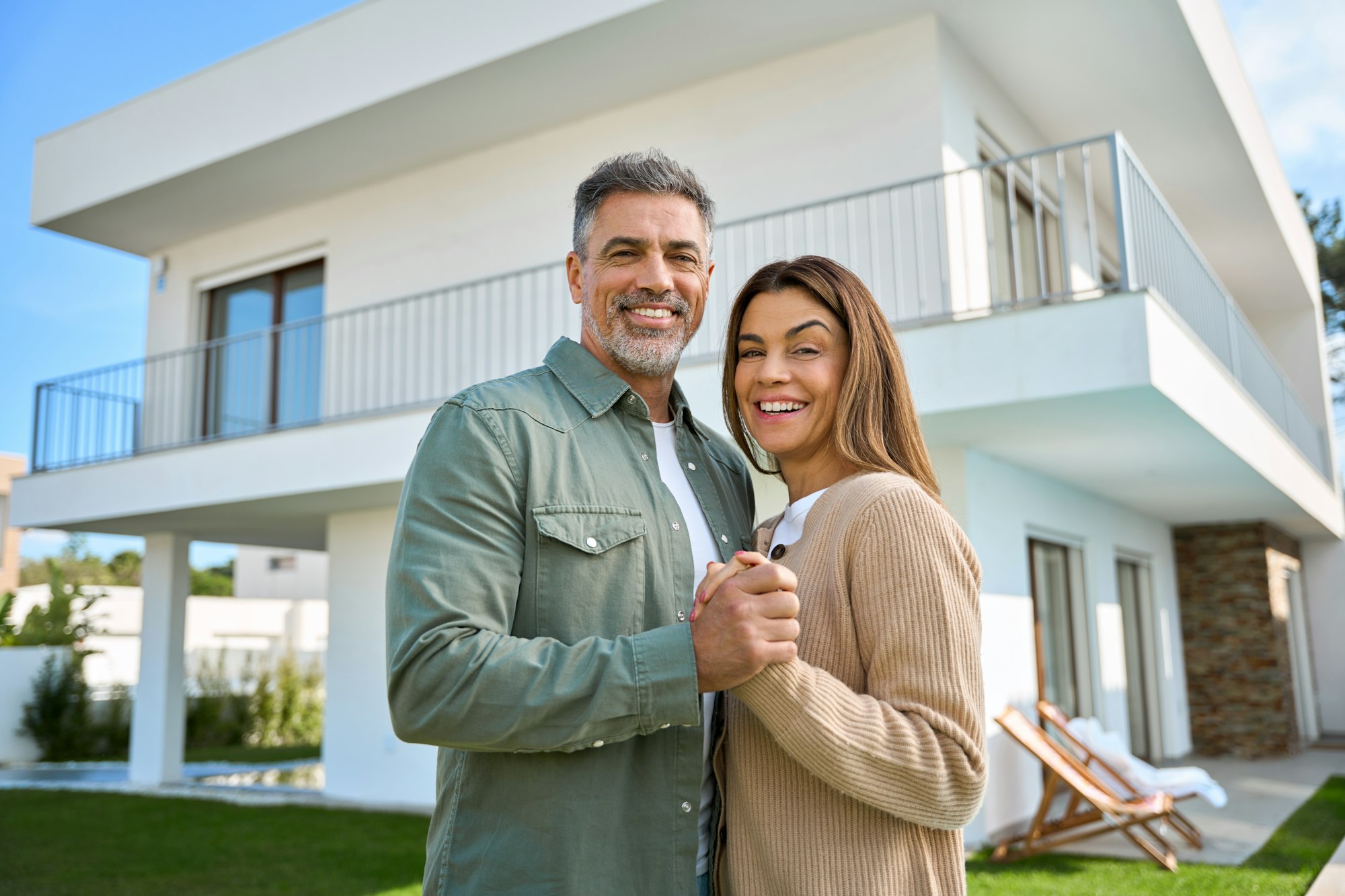 Happy couple standing in front of their luxury property in Mallorca